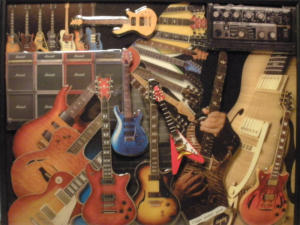 A bunch of guitars are lined up on the wall