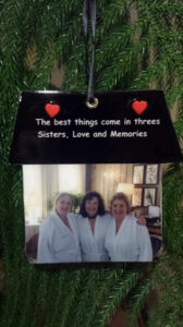 Three women in white robes are hanging from a string.