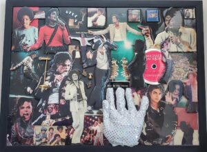 A collage of michael jackson memorabilia with a hand holding a cell phone.